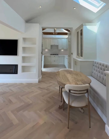 Bespoke banquette seating designed to create a practical dining area within a converted garage and open-plan living space.