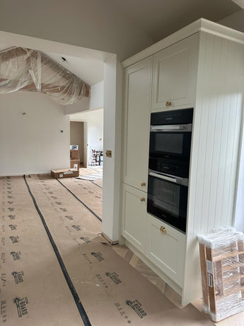 Open-plan kitchen and living area created during a garage conversion in Bowdon, featuring bespoke kitchen cabinetry and a cohesive interior design.