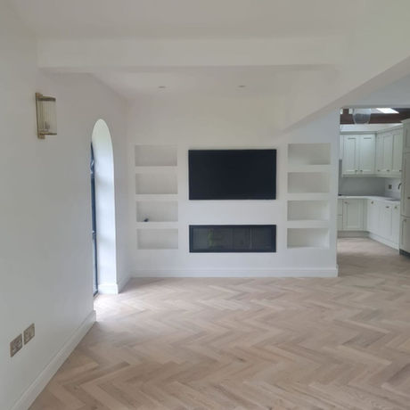 Bespoke built-in media wall with recessed display shelving, television and contemporary inset fireplace in a converted garage in Bowdon.