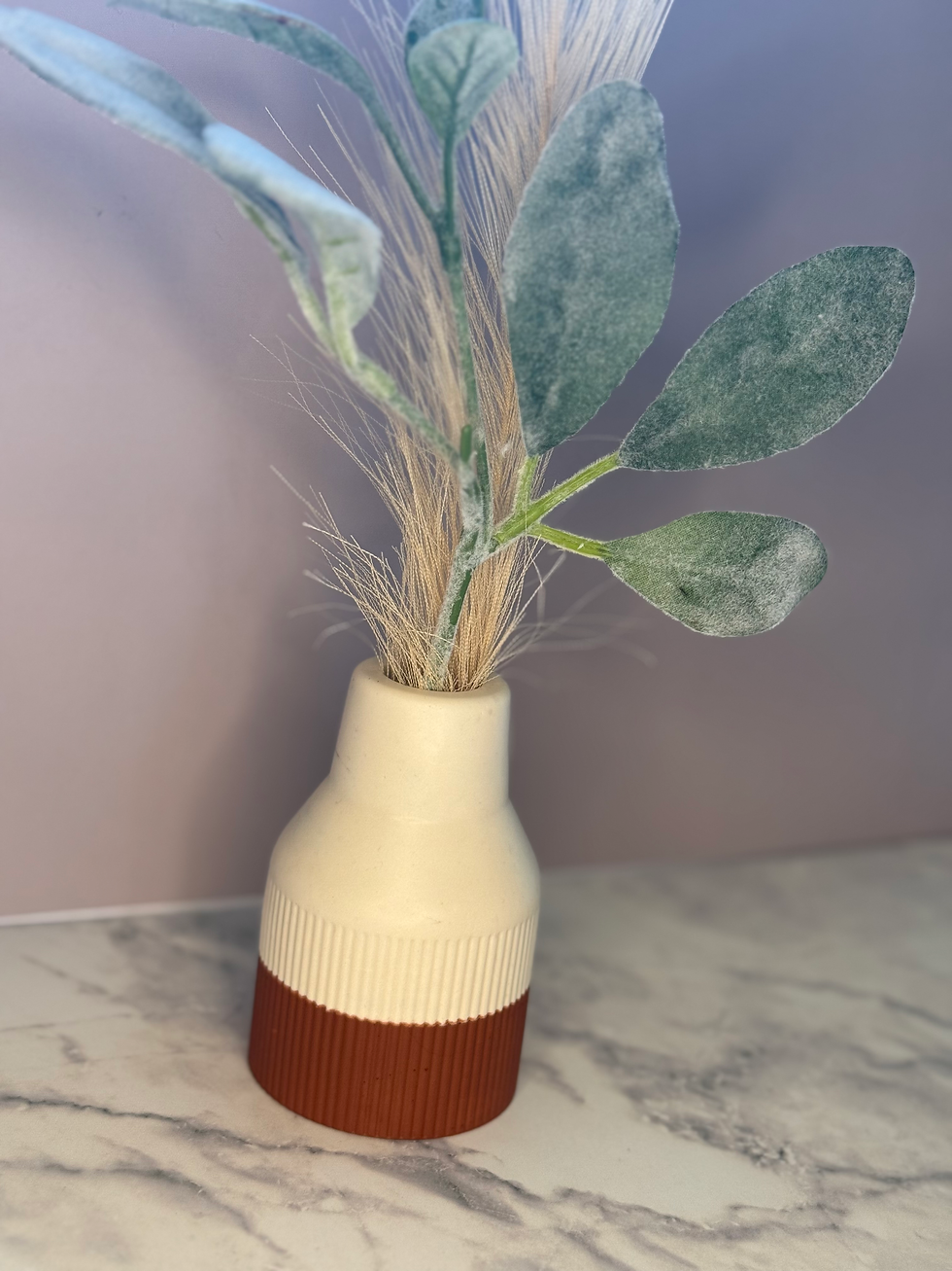 Thumbnail: Floral arrangement in a Terra Cotta & White Reed Diffuser Vase indoors on counter.