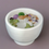 Thumbnail: White candle in a ceramic bowl with flower petals and herbs.