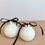Thumbnail: Two white ceramic ball-shaped trinket boxes with black ribbons and gold accents