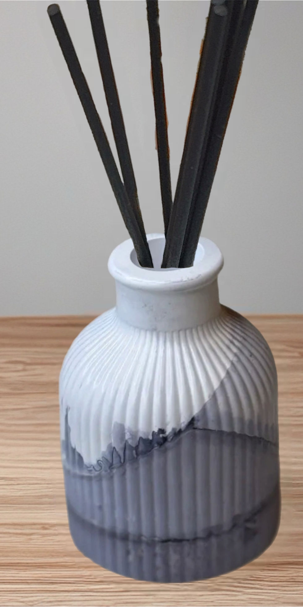 White and grey ribbed vase with black reeds, minimal home decor.