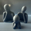 Thumbnail: Three neutral sculptures with folded hands and heads resting on hands