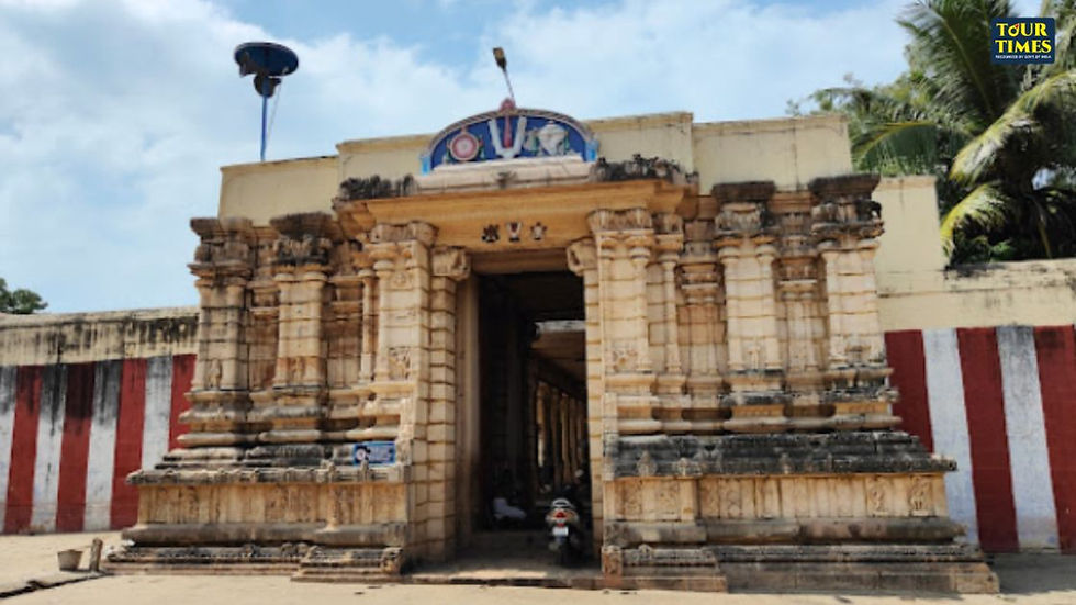 Stone temple entrance with carved columns and red-white walls, palm trees behind, under a bright sky; Tour Times watermark. Thirupuliyangudi Perumal Temple
