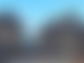 Ancient stone temple with intricate carvings, surrounded by a crowd of visitors. Clear blue sky in the background, adding a serene atmosphere.Trimbakeshwar Temple