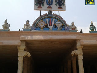 Hindu temple facade with carved deities and sacred symbols on the roof, under a bright sky; Tour Times watermark. Thirupperai Temple
