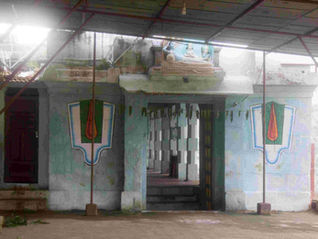 Colorful temple facade under a roof canopy, with deity mural, patterned walls, and a foggy courtyard, no people visible. Thiru Kabisthalam Temple