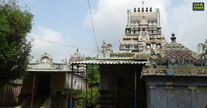 Ancient temple with ornate carvings and colorful details under a cloudy sky. Lush greenery surrounds, and "Tour Times" is visible.Thiruthetriyambalam Temple