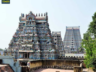 Colorful, ornate temple towers rise against a clear sky, with intricate carvings and vibrant statues. Greenery surrounds the ancient structure. Pancha Bootha Sthalam