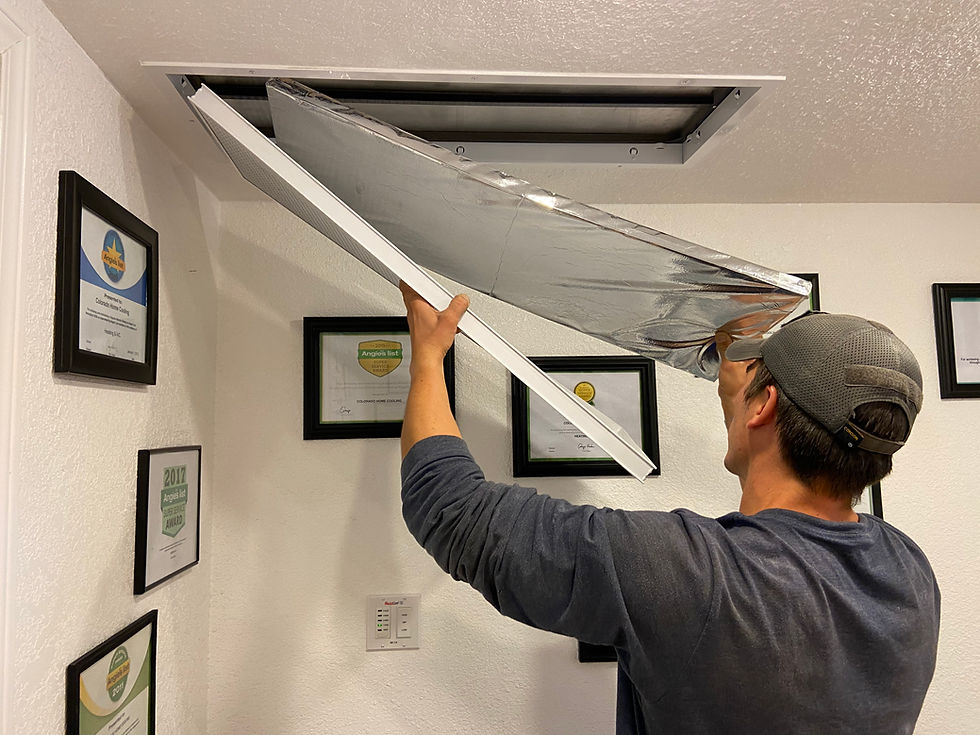 A man installing a insulated insert into the whole house fan ceiling grate.