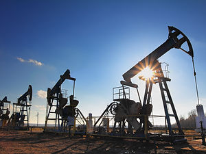 working oil pumps silhouette against sun.jpg