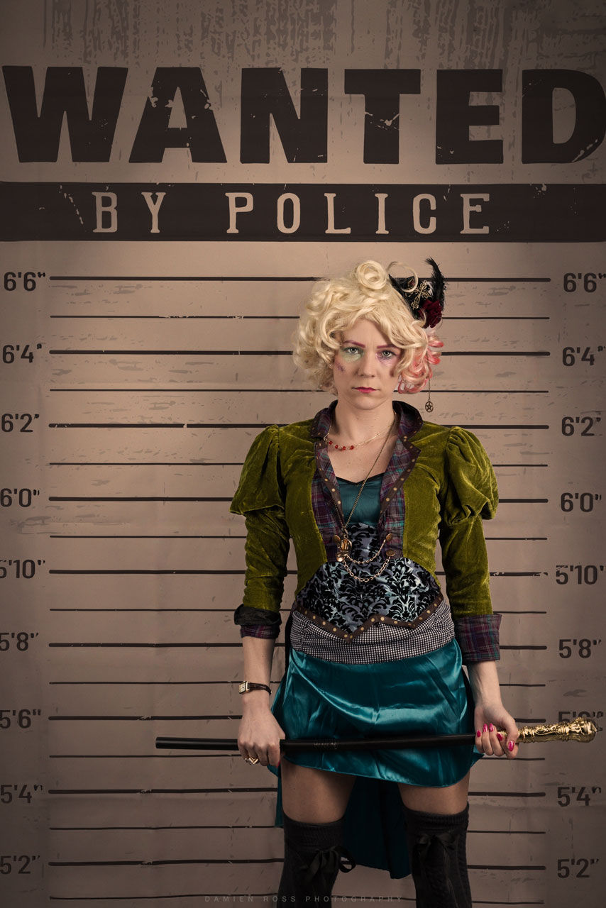 Creative fun portrait, the bad hatter in front of a wanted sign, taken in the studio.