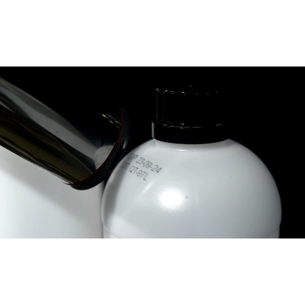 Tête d’impression près de l’épaule d’un flacon blanc à bouchon noir