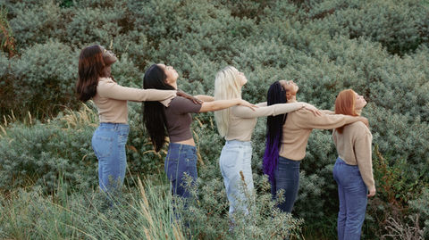 Fashion shoot of 5 girls in a field