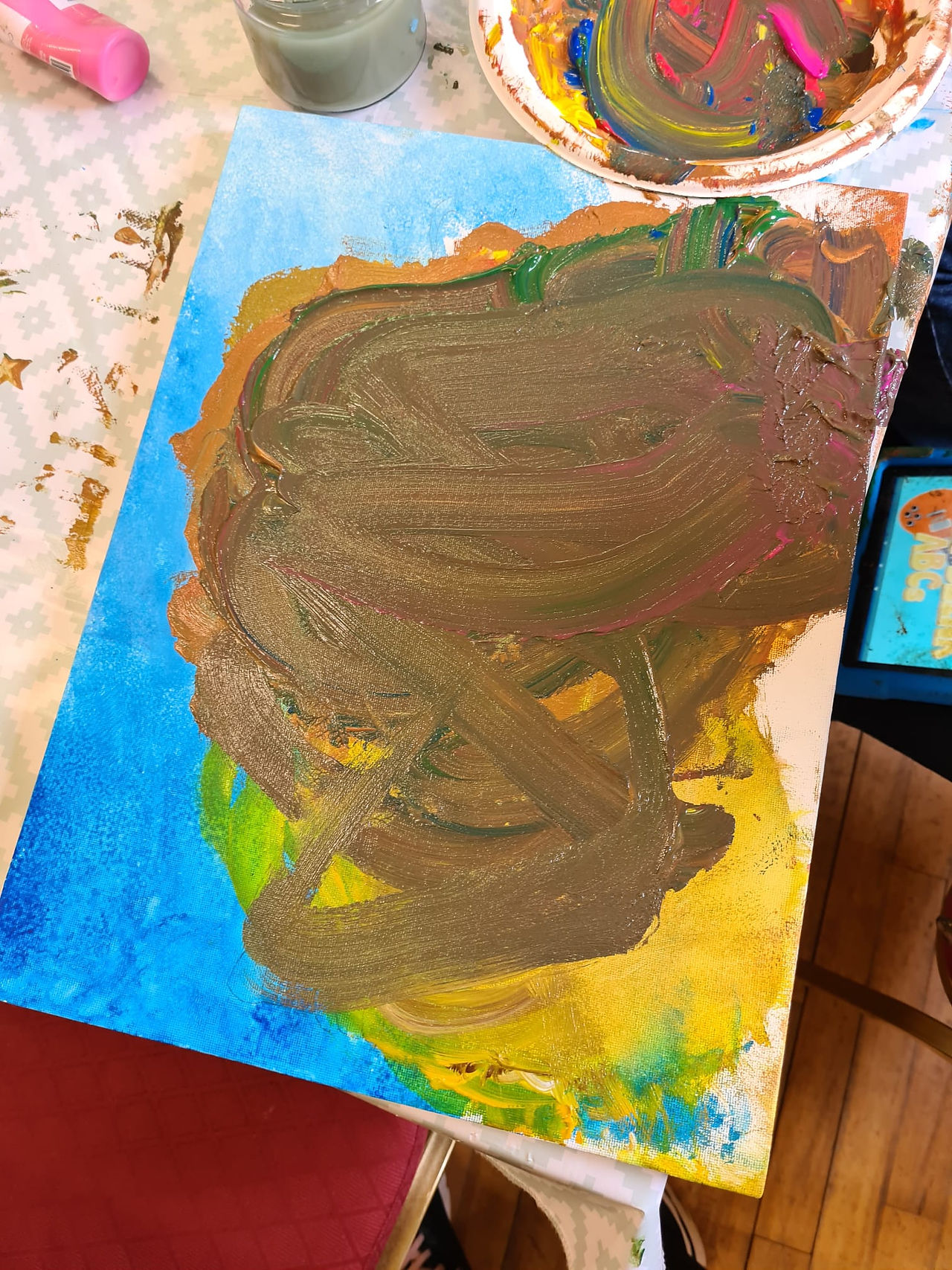 Families painting Easter-themed hare artworks together at Sayers Studio’s Mummy & Me Class in Inch Community Centre, surrounded by colourful art supplies and joyful expressions.