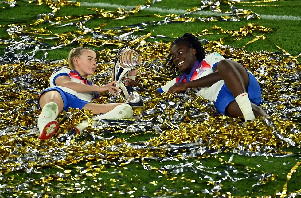 Chloe Kelly and Michelle Agyemang of England celebrate with the trophy after beating Spain.