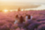 women-with-hands-up-sitting-lavender-field-sunset.jpg