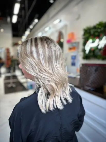 Platinum blonde balayage with soft waves styled in Sugar Land salon