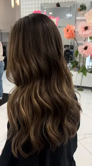Long brunette balayage with soft curls at Hello Beautiful Signature Salon