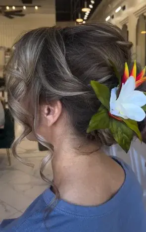 Elegant updo hairstyle with floral accessory at Houston salon