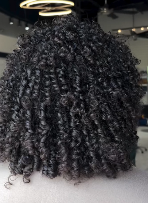 Fresh tight curls styled on dark hair at a curly hair salon in Houston.