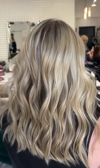 Bright blonde wavy hairstyle at Hello Beautiful Signature Salon