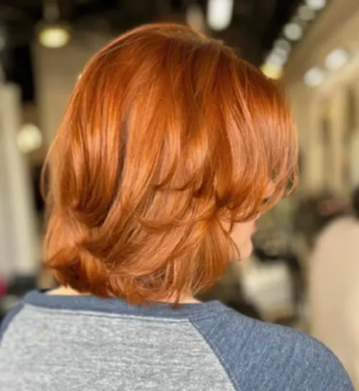 Layered red bob haircut styled at Hello Beautiful Signature Salon in Sugar Land