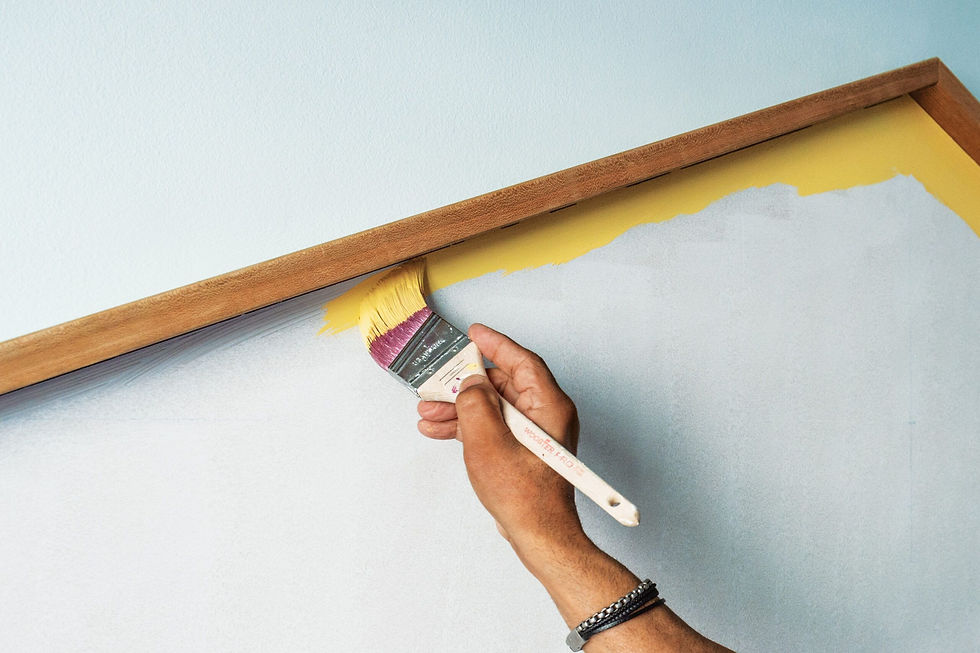 Close-up of a painter carefully edging a wall with a brush, cutting in along the ceiling and trim.