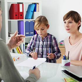 Une mère et son en consultation dans le bureau d'un professionnel.
