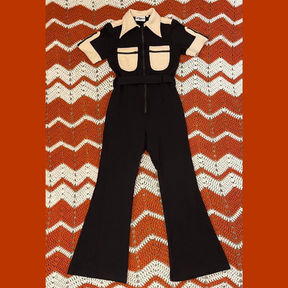 A dark brown 70's-style jumpsuit with cream breast pockets and collar.