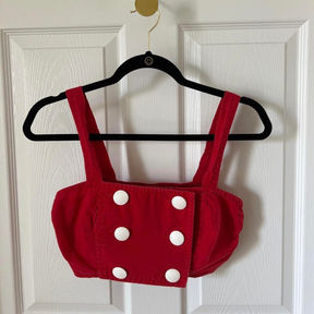 A red vintage crop top with two columns of white buttons on the front.