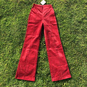 A pair of red high-waisted wide-leg corduroy pants with decorative seams down the front of either leg.