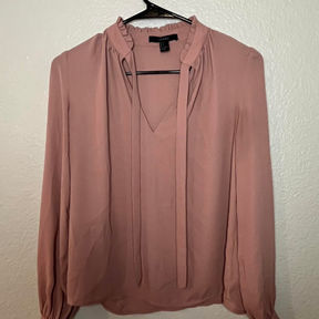 A dusty rose long-sleeved blouse with ruching and a pussy bow at the neck.