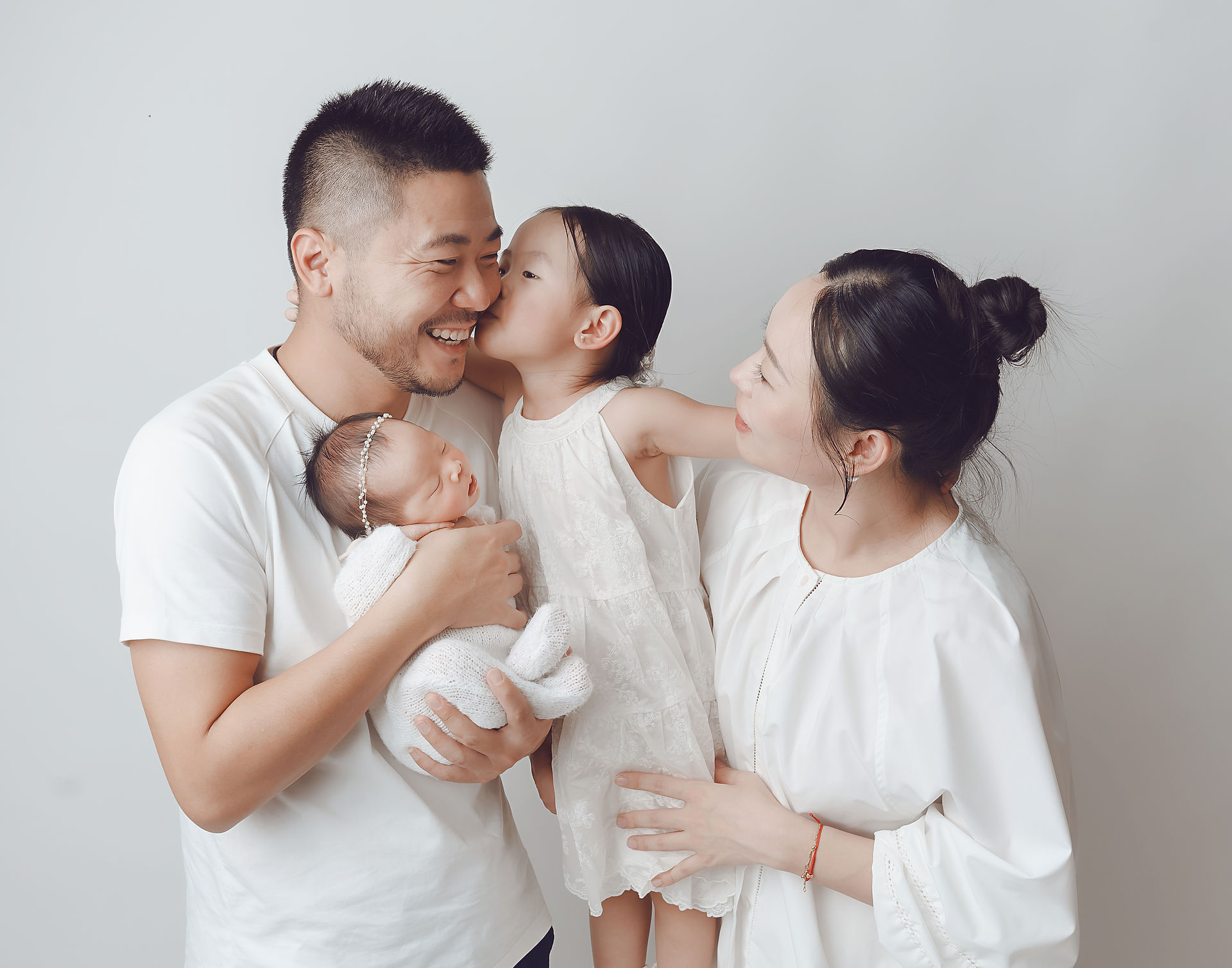 Fotografia de bebé dormindo nas mãos do pai em fotografia de família de sessão fotográfica de recém nascido