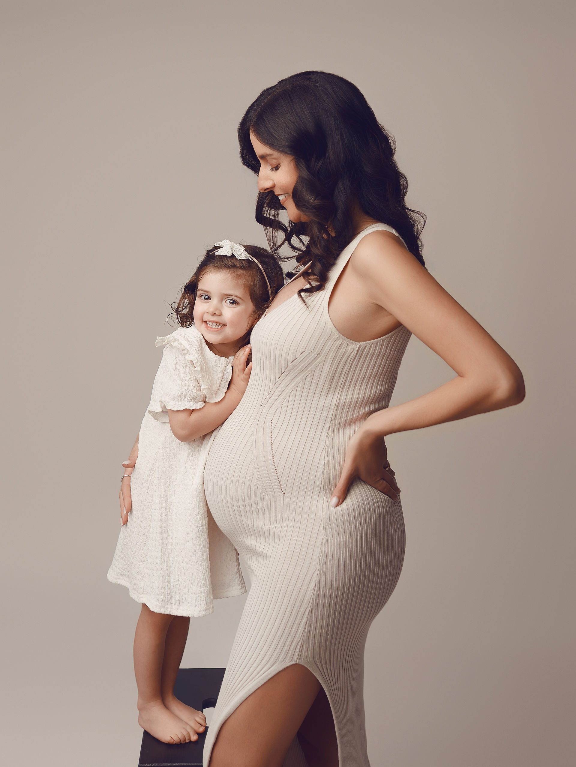 mãe e filha posando em sessão fotográfica de grávida