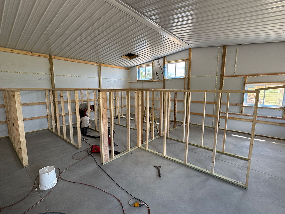 Interior of the new CW Bernedoodles puppy nursery under construction, featuring freshly framed training and nursery rooms inside a spacious insulated building with concrete floors and natural light.