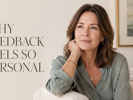 a woman sitting with a self-reflective expression in a calm neutral setting. text overlay: why feedback feels so personal