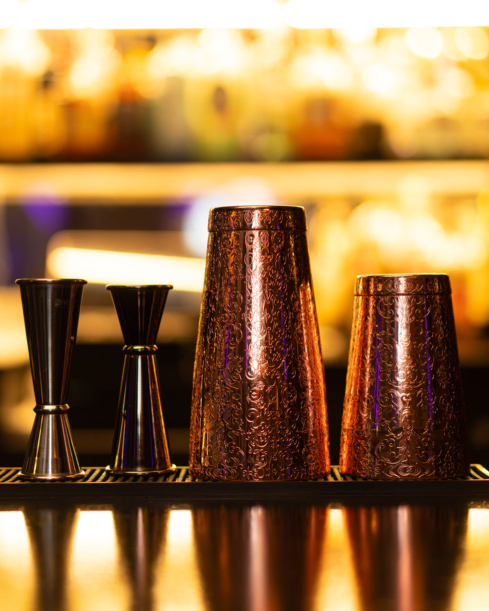 etched Cocktail shakers resting of the Figs and Fables bar