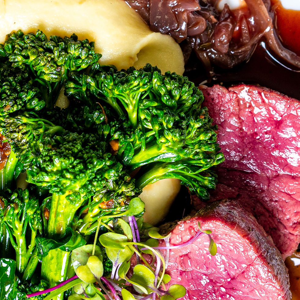 Closeup of broccolini, steak, and mashed potatoes