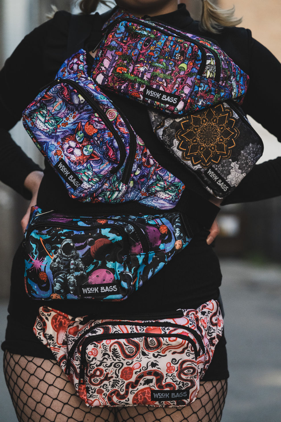 Woman in black onesie wearing five fanny packs