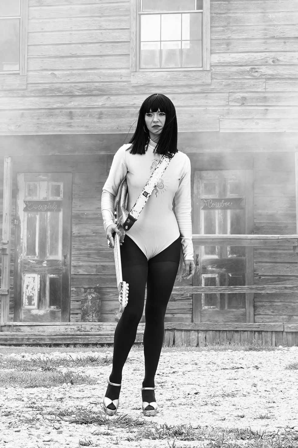 Khruangbin lead vocalist Laura Lee with guitar stapped across her chest during the filming of the b-sides music video featuring Leon Bridges