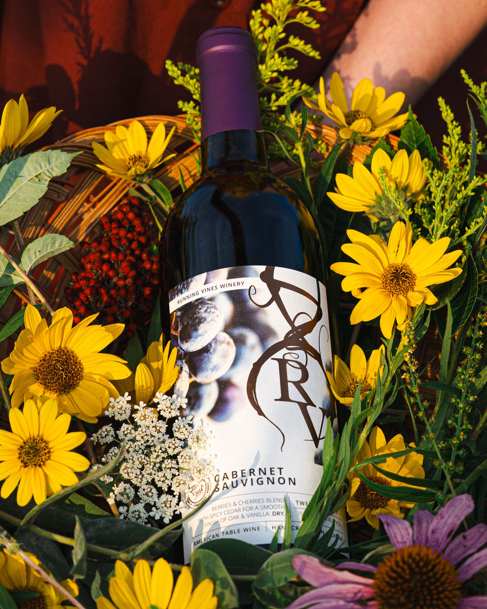 Cabernet Sauvignon bottle of wine nestled amongst Indiana wildflowers in a whicker basket