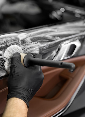 Washing with foam and detergent using a brush on the inner surface of the car door. Car de