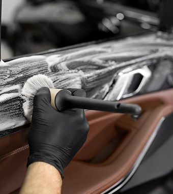 Washing with foam and detergent using a brush on the inner surface of the car door. Car de