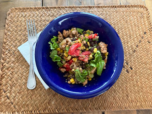 Turkey taco quinoa bowl with black beans, corn, tomato, and romaine in a blue bowl