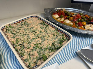 White bean and kale skordalia in a baking dish, served with roasted cod with tomatoes and olives
