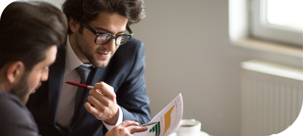 Business professionals reviewing financial charts and data during a meeting, discussing strategy and analyzing performance reports.
