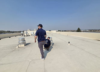 Inspector walking a commercial roof during an inspection