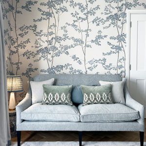 a lamp with a blue shade sits on a table next to a potted plant